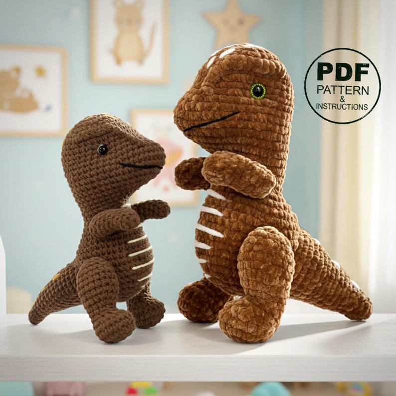 May include: Two brown crocheted dinosaur toys. The larger dinosaur has white stripes and a green eye. The smaller dinosaur has white stripes. The image includes a circular graphic with the text "PDF PATTERN & INSTRUCTIONS".