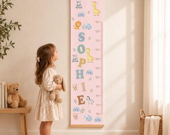 May include: A vertical pink growth chart wall hanging featuring the name SOPHIE in large letters, decorated with illustrations of a giraffe, lion, hippo, elephant, zebra, monkey, and rainbows, with a measurement scale from 80cm to 160cm.