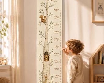 May include: A vertical canvas growth chart hanging on a wall, featuring a birch tree illustration with a squirrel, a bear in a hollow, and a rabbit. The text reads GROWING WITH OLIVER. It includes measurement markings in both centimeters and inches.