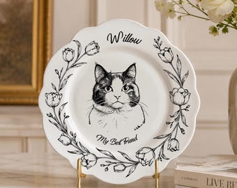Könnte beinhalten: Ein weißer Keramikteller mit gewelltem Rand und einer schwarzen Strichzeichnung einer Katze in der Mitte. Der Text Willow steht über der Katze und My Best Friend darunter. Ein schwarzer Blumenkranz aus Tulpen umrahmt die Katzenillustration.