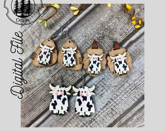 May include: Four pairs of cow-themed earrings. Each pair features a different design, including a cow with the word "Moo" on a triangular shape, a cow on a rounded shape, and a cow on a scalloped shape. The earrings are made of wood and painted in black and white with pink accents.