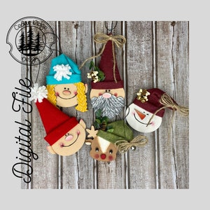 May include: Five wooden Christmas ornaments with different faces. The ornaments are painted in various colors, including red, blue, green, white, and brown. The ornaments are hanging from a wooden background.