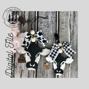 May include: Two black and white cow head ornaments with wooden tags. The tags say "Mamaw" and "Hey Y'all". The ornaments are decorated with black and white gingham and cow print bows.