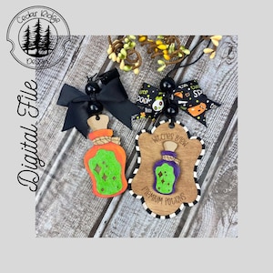 Könnte beinhalten: Zwei hölzerne Halloween-Potionflaschen-Ornamente mit grüner und violetter Potion, schwarz-weiß gestreiftem Besatz und dem Text "Witches Brew Premium Potions".