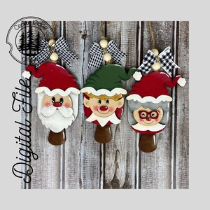 May include: Four wooden Christmas ornaments featuring Santa Claus, an elf, and two Mrs. Claus characters. The ornaments are painted in red, green, white, and black.