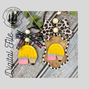 May include: Two wooden pencil-shaped ornaments with a yellow and pink design. One ornament has the text "Teach Love Inspire" and the other has a colourful bow.