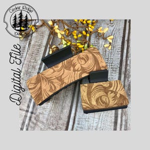 May include: Two brown wooden hair clips with a black metal clip. The wood has a decorative floral pattern.