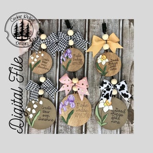 May include: Six wooden round ornaments with different floral designs and inspirational quotes. The quotes are "Create your own sunshine", "Make today amazing", "Good things take time". Each ornament has a white wooden bead and a black and white, pink and gold, or black and white cow print bow.