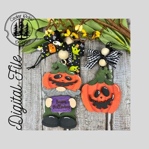 Könnte beinhalten: Zwei Halloween-Holzornamente. Eines ist ein Kürbis-Zwerg, der ein Schild mit der Aufschrift "Happy Halloween" hält. Das andere ist ein Kürbis mit einem Kürbisgesicht.