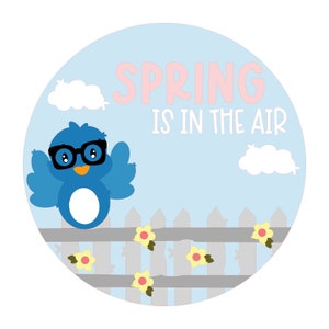 May include: A blue bird wearing glasses sits on a gray picket fence with yellow flowers. The background is a light blue sky with white clouds. The text "SPRING IS IN THE AIR" is written in pink letters.