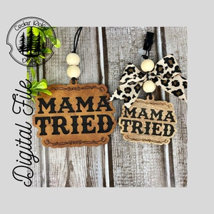 May include: Two wooden car air fresheners with the text "Mama Tried" in black lettering. One air freshener is attached to a white beaded string with a leopard print bow. The other air freshener is attached to a clip.