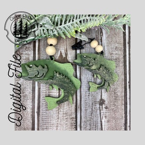 Pode incluir: Dois ornamentos de peixe verde com uma conta de madeira e um clipe. Os peixes são pintados com um padrão de camuflagem e têm um efeito 3D.