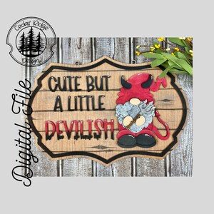 May include: A wooden sign with a black border and the text "Cute but a little Devilish" in black lettering. A red devil gnome with a pitchfork is on the right side of the sign.