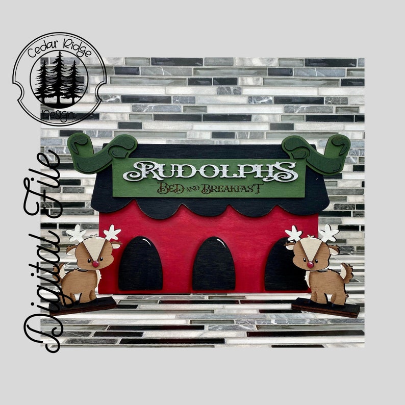 Op de afbeelding: Een rood en zwart houten bord met de tekst "Rudolph's Bed and Breakfast" in witte letters. Twee rendierfiguren staan aan weerszijden van het bord.