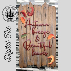 May include: A wooden sign with a distressed finish featuring the text "Autumn breeze & Beautiful leaves" in red lettering. The sign is decorated with fall-colored leaves.