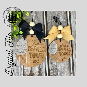 May include: Two wooden ornaments featuring a water tower design and the text "Just a Small Town girl". The ornaments are adorned with black and yellow bows and white beads.