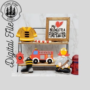 Könnte beinhalten: Eine dekorative Regal-Anordnung mit Feuerwehr-Motiv. Enthält ein Holzschild mit dem Text "My Heart Belongs to a Firefighter", einen Feuerwehrwagen, eine Feuerwehrjacke, einen Zwerg, einen Hydranten und einen Stiefel.