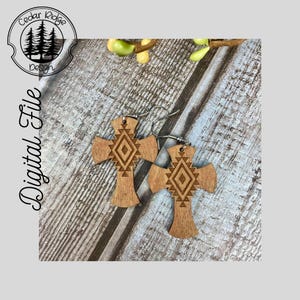 May include: A pair of wooden cross earrings with a geometric pattern carved into the wood. The earrings are brown and have silver hooks.