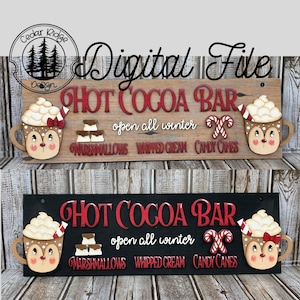 K&ouml;nnte beinhalten: Zwei Holzschilden mit dem Text "HOT COCOA BAR" in roten Buchstaben. Die Schilder sind mit einem Rentier verziert, das eine Tasse hei&szlig;e Schokolade h&auml;lt, Marshmallows, Schlagsahne und Zuckerstangen. Der Text "open all winter" steht unter dem Haupttext.