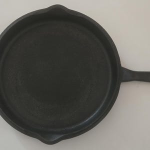 Padella in ghisa Cabelas da 12 pollici con doppio manico e doppio fondo, già pronta all'uso.