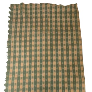 May include: A rectangular textile throw featuring a repeating pattern of vertical green stripes alternating with light beige stripes. The green stripes are decorated with a small, repeating floral motif. The left edge has a fringed finish.