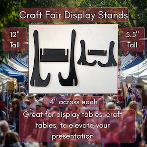 May include: Black craft fair display stands. One stand is 30.5 cm tall, the other is 14 cm tall. Each stand is 10 cm across. The image text says "Craft Fair Display Stands" and "Great for display tables, craft tables, to elevate your presentation."
