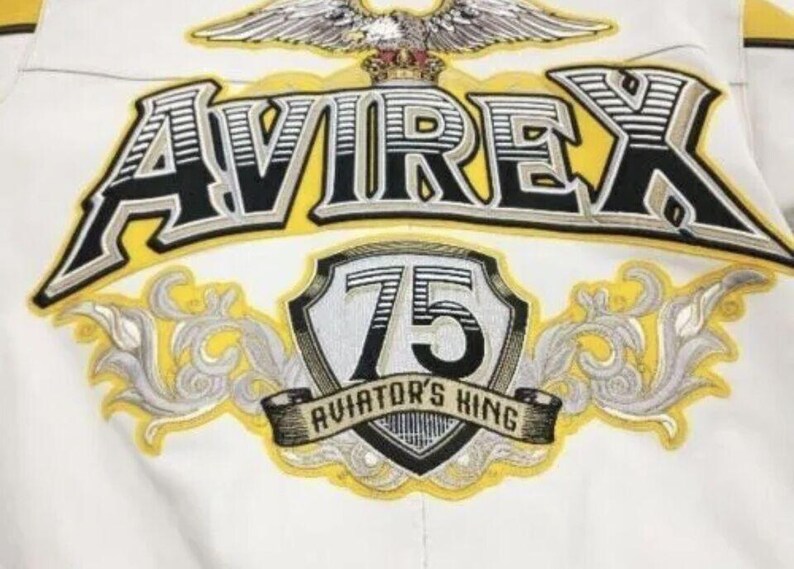 May include: A white ceramic mug with a black handle and the text "But First, Coffee" in a black, handwritten-style font. The mug is on a white surface.