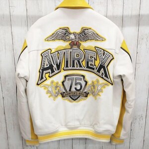 May include: White and yellow bomber jacket with the word "AVIREX" and an eagle emblem on the back. The jacket has yellow stripes on the sleeves and a yellow collar. The text "75 AVIATOR'S KING" is also visible.