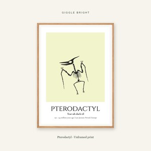 Puede incluir: Una l&aacute;mina enmarcada con una ilustraci&oacute;n negra del esqueleto de un pterod&aacute;ctilo sobre un fondo amarillo p&aacute;lido. Debajo del gr&aacute;fico, el texto dice PTERODACTYL, Tear-uh-dack-til, 150-145 million years ago, Late Jurassic Period, Europe.
