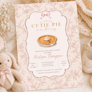 Könnte beinhalten: Eine rechteckige Babyparty-Einladungskarte mit rosa Blumenmuster, einer zentralen Abbildung eines Kürbiskuchens und einer rosa Schleifengrafik. Der Text lautet A LITTLE CUTIE PIE is on the way, zu Ehren von Madison Thompson, mit Veranstaltungsdetails.