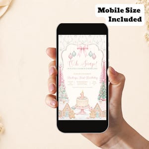 May include: A smartphone displaying a digital birthday invitation with the text Oh Snap! Our Little Cookie Is Turning One! and Hadleys First Birthday. The design features pink and blue ornaments, a cake with a number one candle, and gingerbread houses.