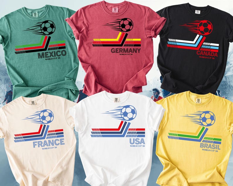 May include: A collection of six t-shirts in various colors, each featuring a soccer ball graphic with country flags and text. The shirts include designs for Mexico, Germany, Canada, France, USA, and Brazil, with the text "WORLD CUP 20" below.