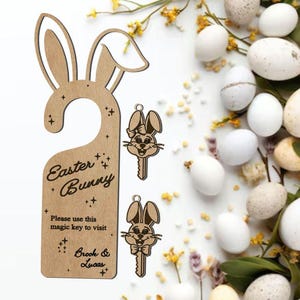 May include: A wooden Easter Bunny door hanger with a key-shaped charm. The door hanger has the text "Easter Bunny" and "Please use this magic key to visit". The image also includes eggs and flowers.