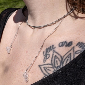 Könnte beinhalten: Eine silberne Halskette mit doppeltem Ketten-Design. Die Halskette hat zwei Anhänger aus klarem Kristall. Der Text "you are my" ist auf der Brust zu sehen.