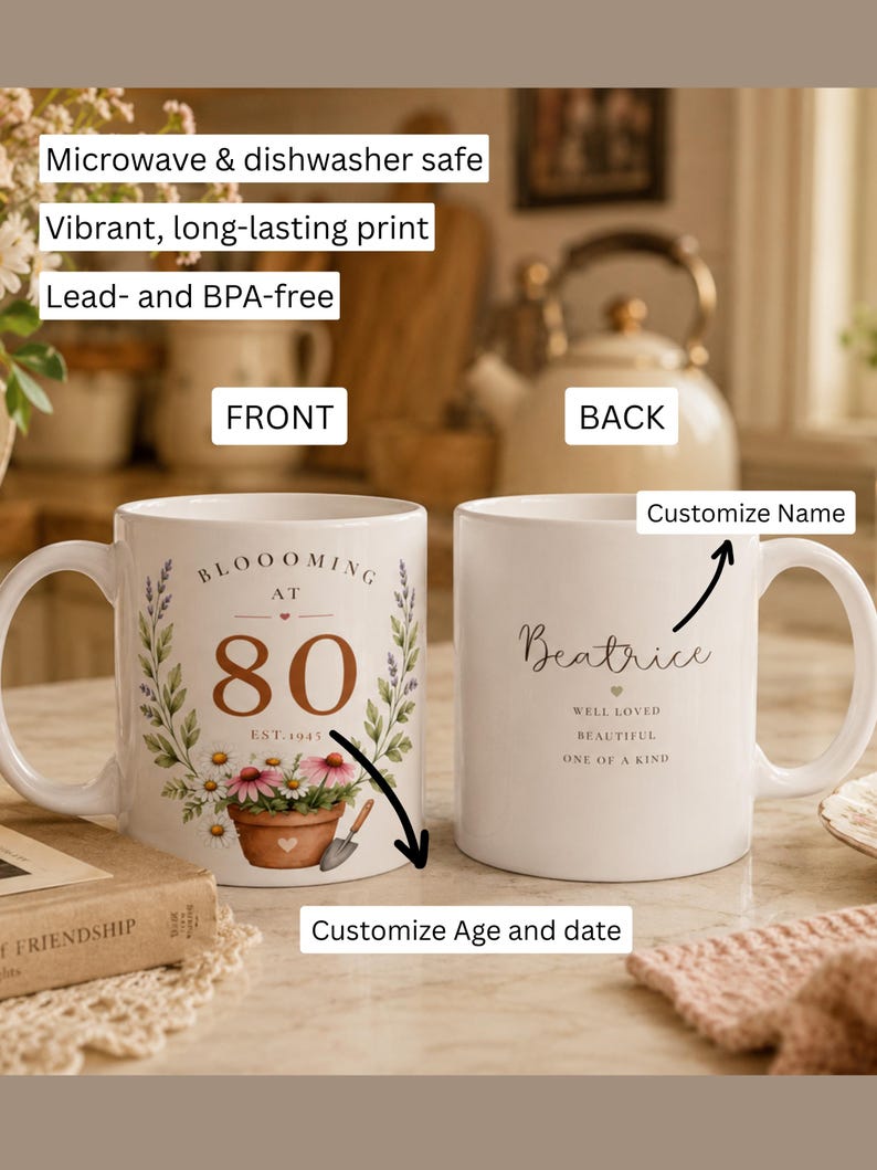 May include: Two white ceramic mugs featuring floral designs. The front mug displays the text BLOOOMING AT 80 EST. 1945 with a potted flower graphic. The back mug shows the name Beatrice with the text WELL LOVED, BEAUTIFUL, ONE OF A KIND.
