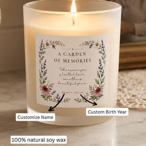 May include: A frosted glass candle with a lit wick and 100% natural soy wax. The label features floral illustrations, the text A GARDEN OF MEMORIES, Wherever you planted love, something beautiful grew, BEATRICE, and EST. 1945, with customization options.