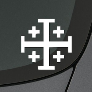 May include: White Jerusalem cross decal, a symbol of Christianity, affixed to a dark gray surface. The cross features a large central cross with four smaller crosses in each quadrant, a common religious emblem.