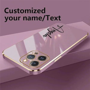 Puede incluir: Una funda de tel&eacute;fono rosa con un borde dorado y el nombre "Angela" en escritura negra. La funda tiene un acabado brillante y presenta un m&oacute;dulo de c&aacute;mara con tres lentes. El texto en la parte superior dice "Customized your name/Text".