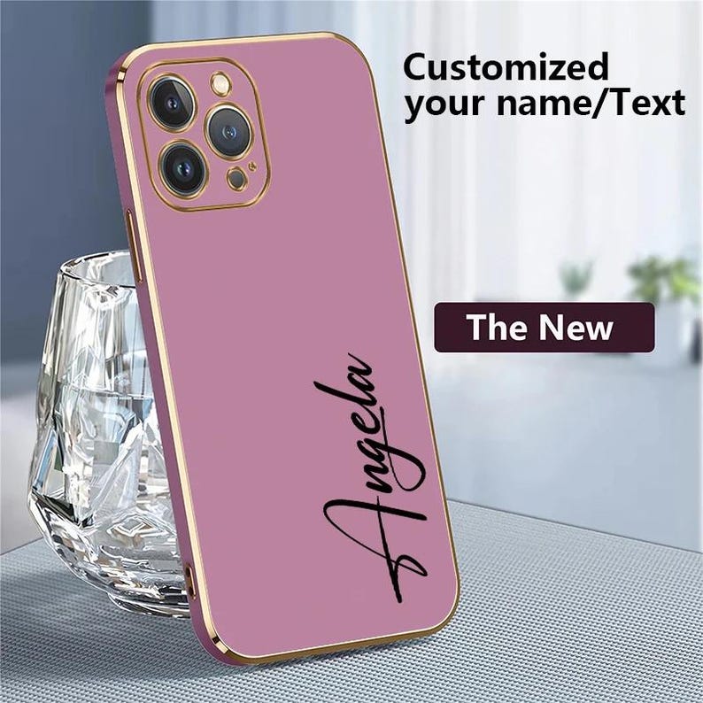 Puede incluir: Funda de tel&eacute;fono m&oacute;vil malva con marco dorado. La funda tiene el nombre "Angela" en fuente negra. Tambi&eacute;n se ve el texto "Customized your name/Text" y "The New".