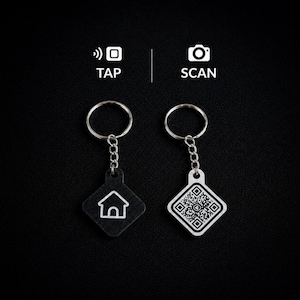 May include: Two square keychains with metal rings and chains. One black keychain features a white house icon with the text TAP above it. The other white keychain displays a black QR code with the text SCAN above it, indicating NFC and scanning functions.
