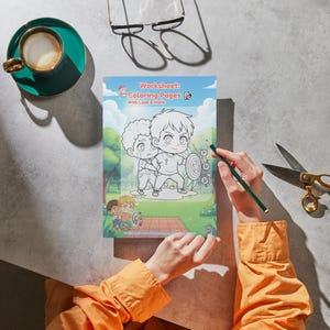 May include: A coloring book titled "Worksheet Coloring Pages With Lions & More" is open on a table. A hand holds a green pencil, ready to color the illustration of two cartoon characters. A cup of coffee and scissors are also on the table.