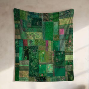May include: A green patchwork tapestry with various shades of green, including emerald, forest, and olive. The tapestry features a mix of patterns and textures, creating a visually rich and textured wall hanging. The design includes floral and geometric elements.