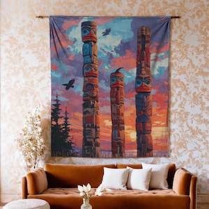 May include: A tapestry depicting three colorful totem poles against a sunset sky with birds in flight. The poles are painted in shades of red, blue, and brown. The tapestry is hanging above a brown sofa with white pillows.