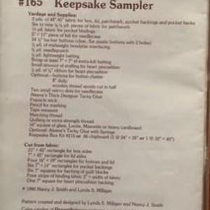 May include: A printed paper titled "Keepsake Sampler" with the text "Page 1 of 2" at the top. The title "Keepsake Sampler" is above the number "#165". The paper includes a list of yards and supplies, and cut fabric measurements. The DreamSpinners logo is at the bottom.