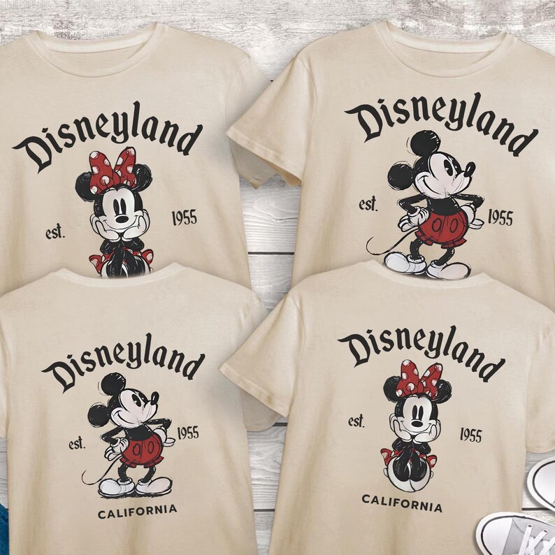 May include: Four cream-coloured t-shirts with Disneyland graphics. Each shirt features a different Mickey or Minnie Mouse design, with the text "Disneyland" and "est. 1955". Two shirts also say "California".
