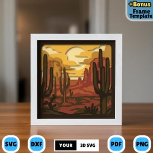May include: A white framed 3D layered paper art piece depicting a desert landscape with cacti, mountains, and a sunset. The artwork features a warm color palette of oranges, browns, and yellows. The bottom of the frame has the text "YOUR 3D SVG".