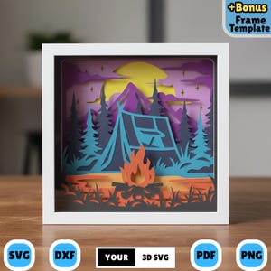 Peut inclure: Une œuvre d'art en papier 3D encadrée représentant une scène de camping. L'œuvre présente une tente bleue, un feu de camp et une chaîne de montagnes sous une lune jaune. Le cadre est blanc, et l'arrière-plan a des teintes violettes et oranges. Le texte "YOUR 3D SVG" est visible.