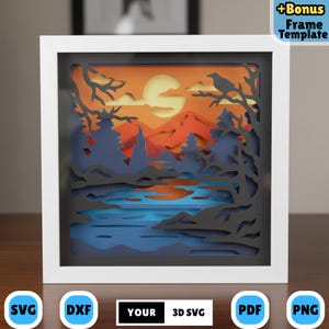 Puede incluir: Una obra de arte en papel en capas en un marco blanco, que representa una puesta de sol sobre un lago y montañas. La escena incluye árboles, un cuervo y un gran sol. El texto "+Bonus Frame Template" es visible.