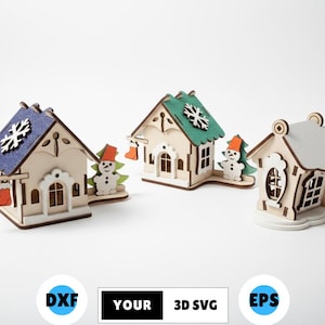 May include: Three wooden Christmas village houses with blue, green, and gray roofs. Each house features a snowflake, a snowman, and a Christmas stocking. The houses are made of light-colored wood with dark brown accents.