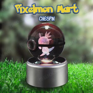 Puede incluir: Una Pokeball esférica brillante con un diseño de Chespin en el interior, sobre una base plateada. Los textos "Pixelmon Mart" y "Chespin" son visibles. El fondo es verde borroso.